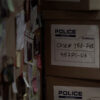 police evidence boxes next to a murder board