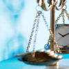 scales of justice with money on one side and clock on the other